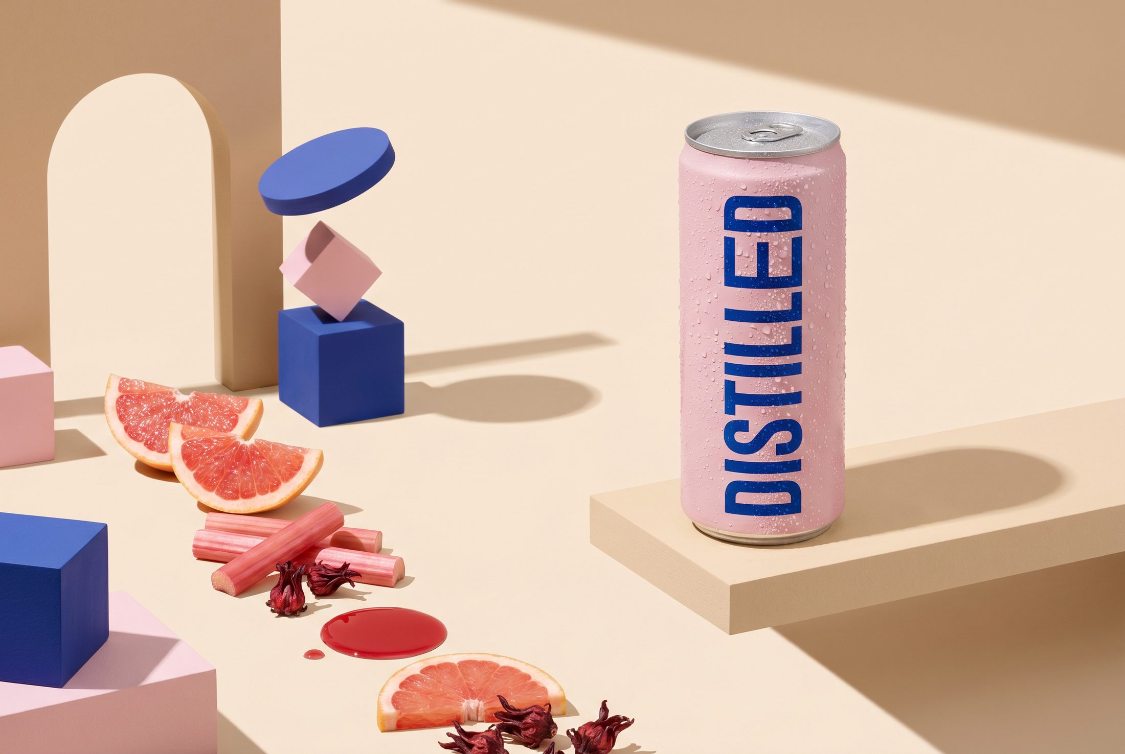 A studio tabletop with pastel geometric blocks and floating fruit