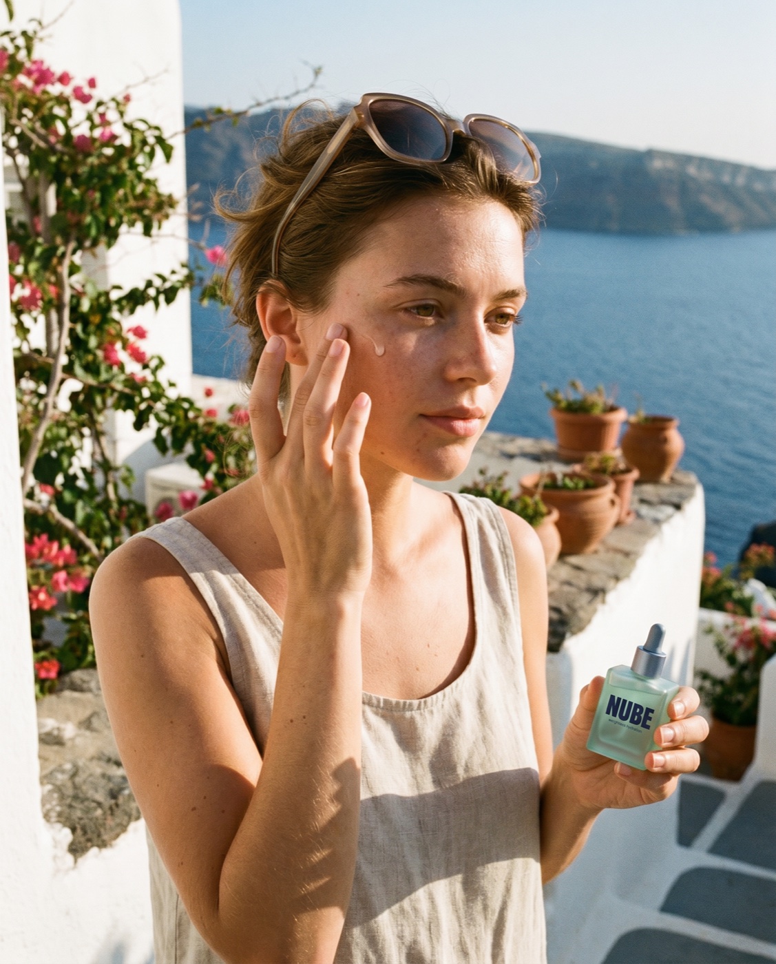 A woman applying the serum, sea behind