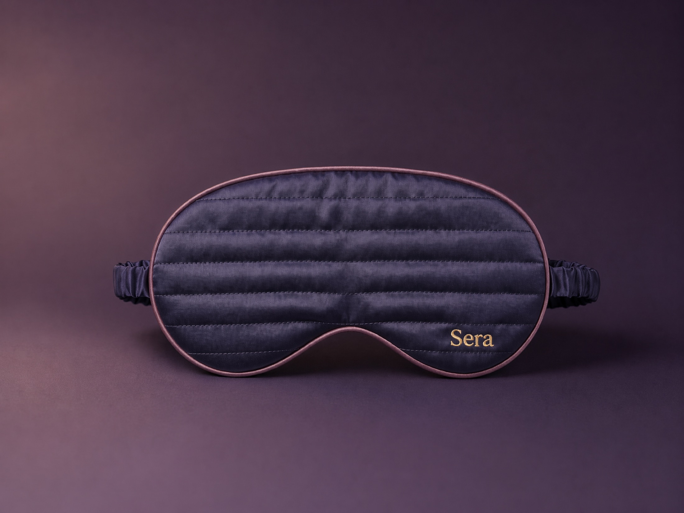 A single Sera mask on a deep twilight-violet studio backdrop