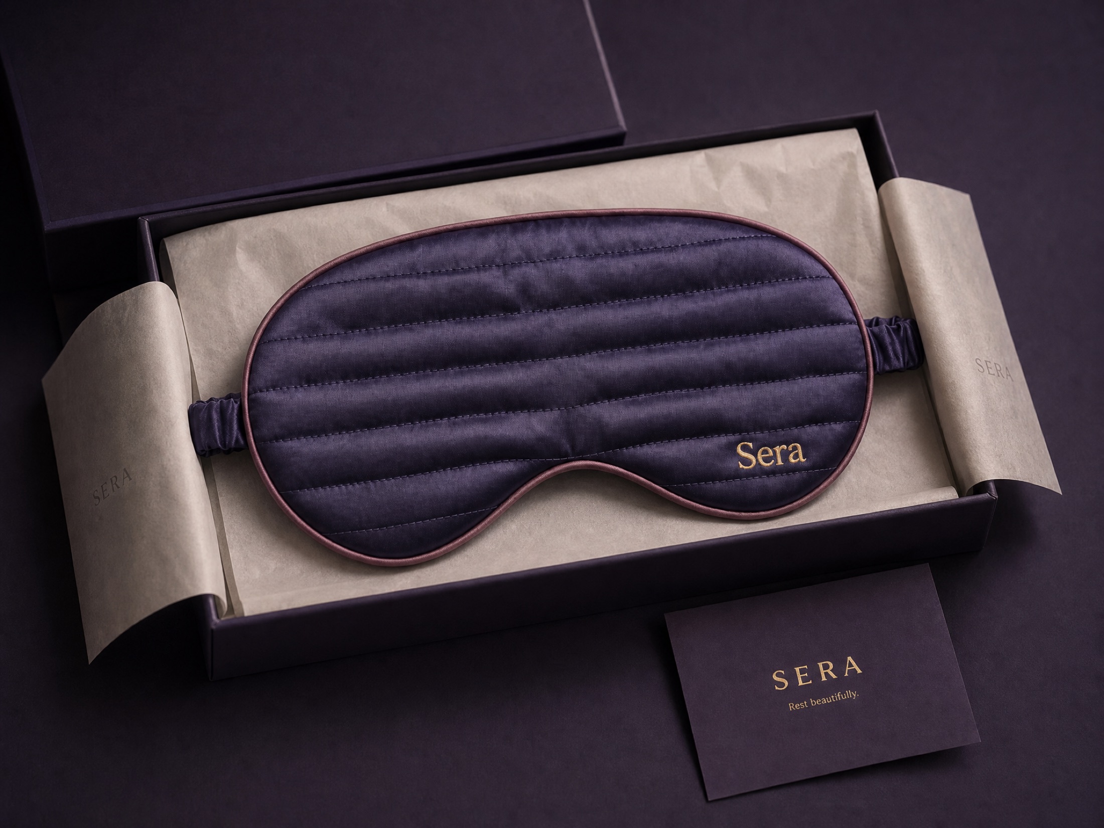 The mask in an open quiet-luxury gift box with tissue and a printed card