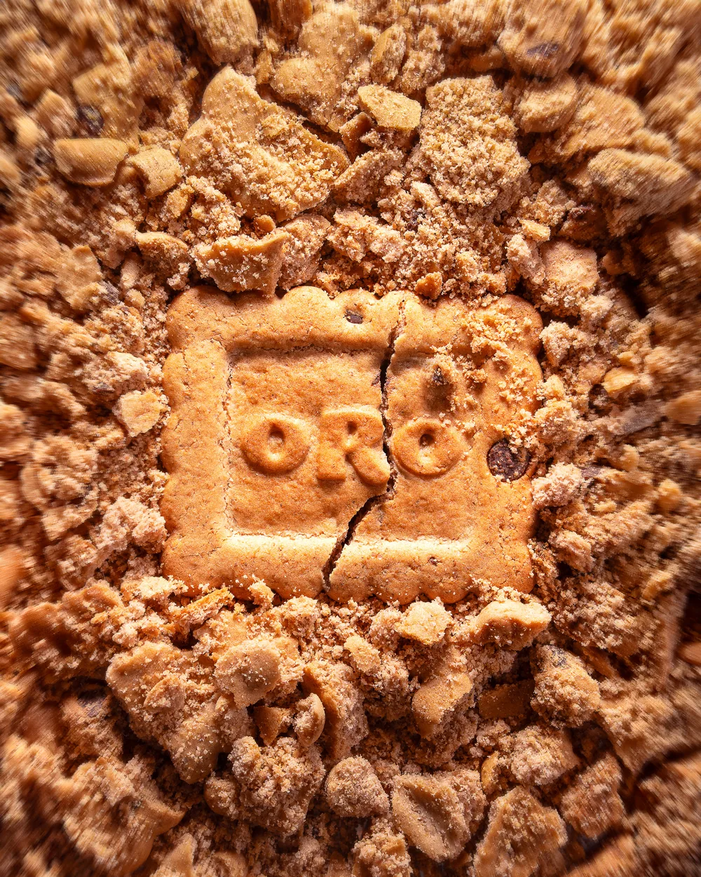 Single Oreo cookie resting in a bed of crushed chocolate crumbs.