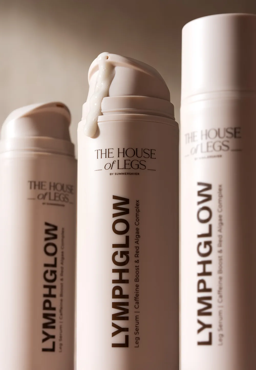 Three The House of Legs Lymphglow leg serum bottles, the centre one crowned with product.