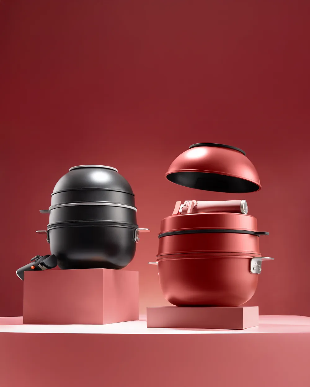 Two stackable MasterPro electric cookers, one black and one red, on pink pedestals.