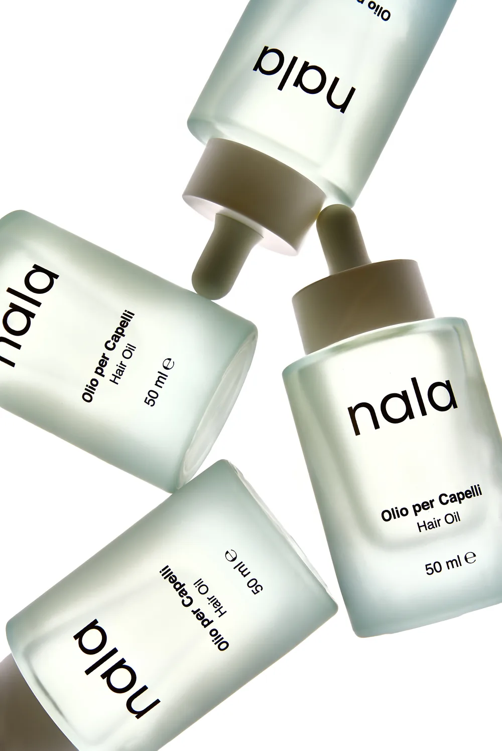 Four Nala Olio per Capelli hair oil bottles floating against a white background.