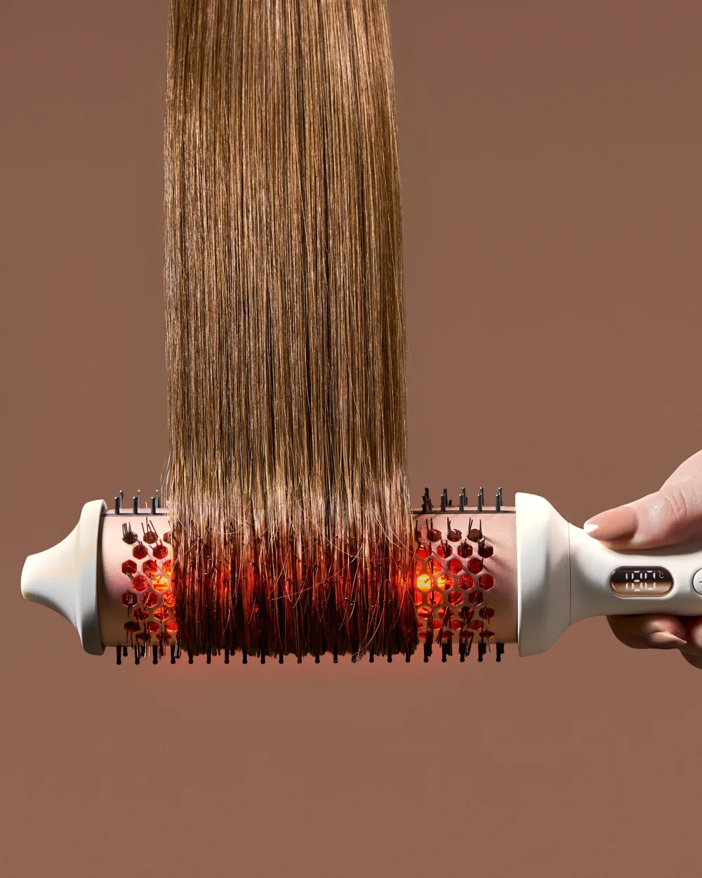 Close-up of long hair drawn through a Nala Therma heated round brush.