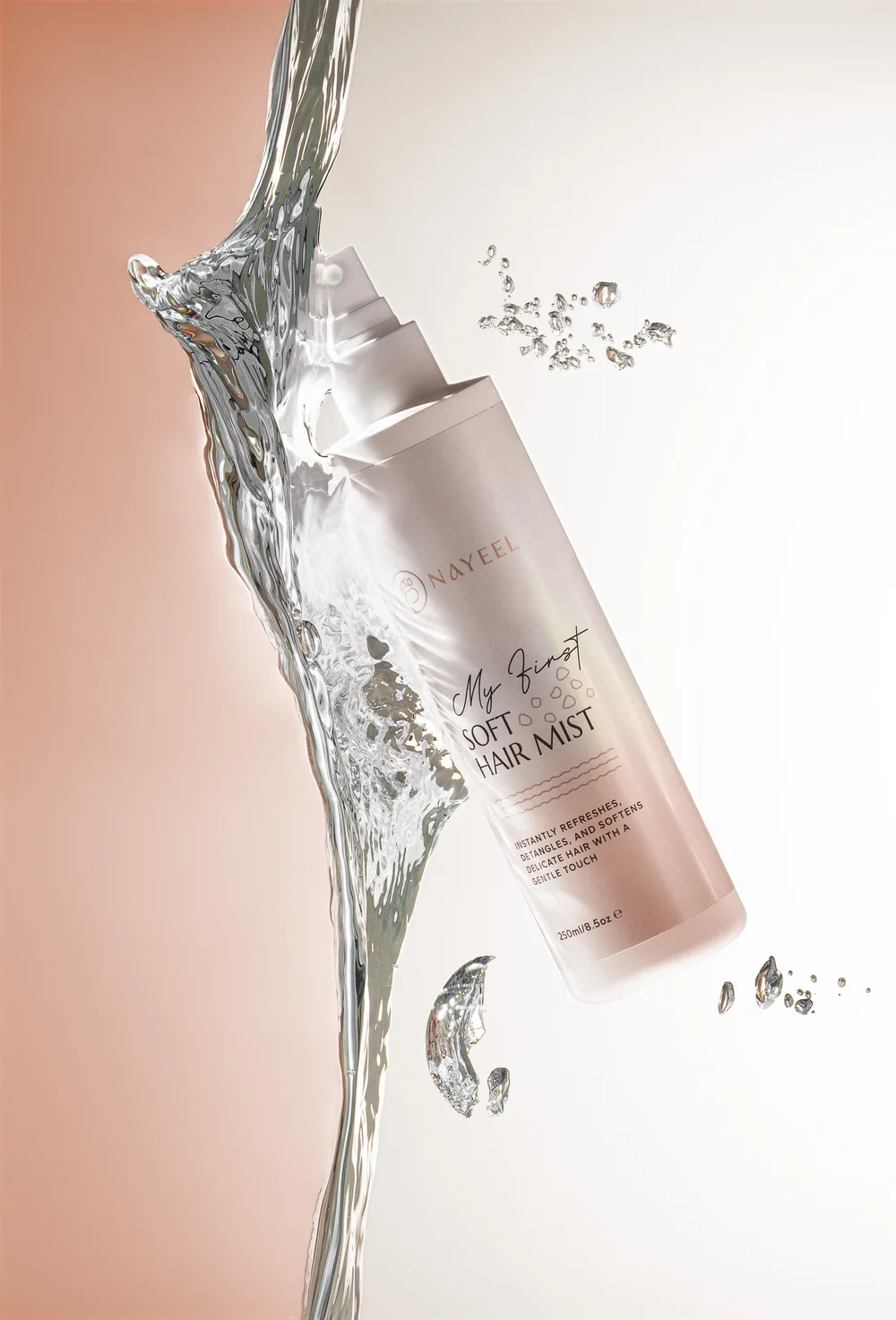 Nayeel hair mist bottle tilted inside a crown of splashing water.